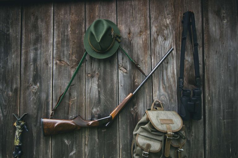 Jagdzubehör und Equipment an einem Holzbrett mit Jagdunfallversicherung von ARGE BW einschließlich Jagdhaftpflichtversicherung